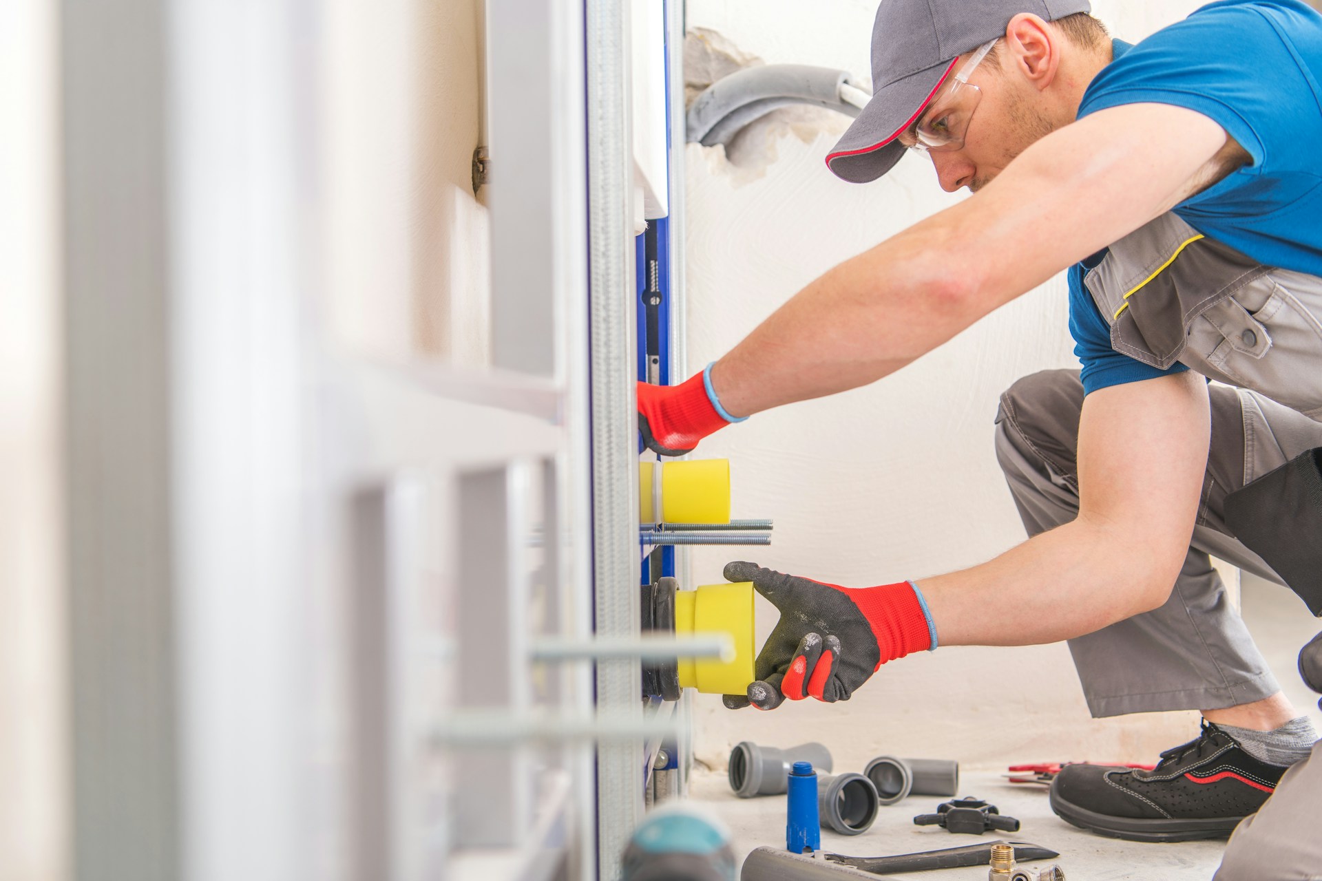 A plumber installing a yellow tube